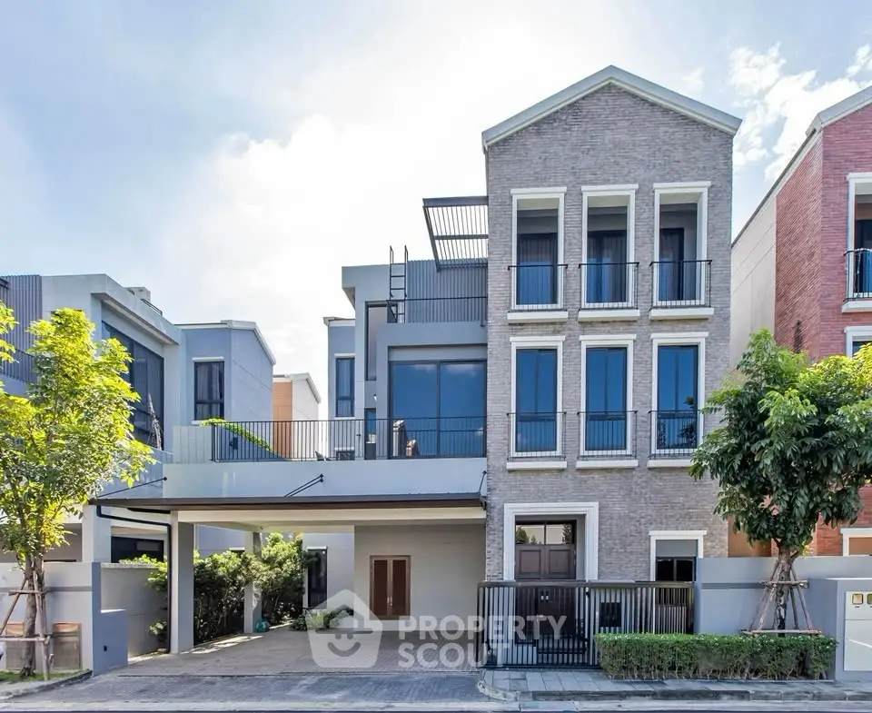 Modern multi-story house with large windows and spacious driveway in a suburban neighborhood.