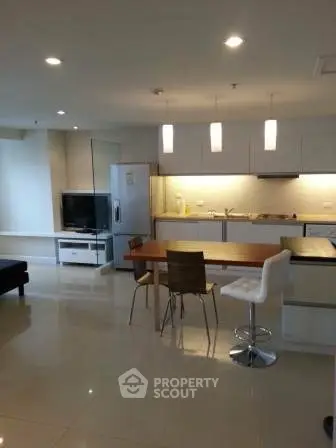 Modern open-layout kitchen and living area with sleek design and ample lighting.