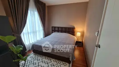 Cozy bedroom with elegant decor and large window, perfect for relaxation and comfort.
