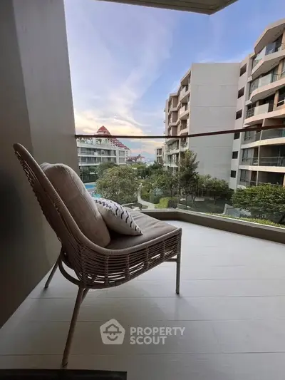 Chic balcony with modern chair and stunning city view in luxury apartment complex.