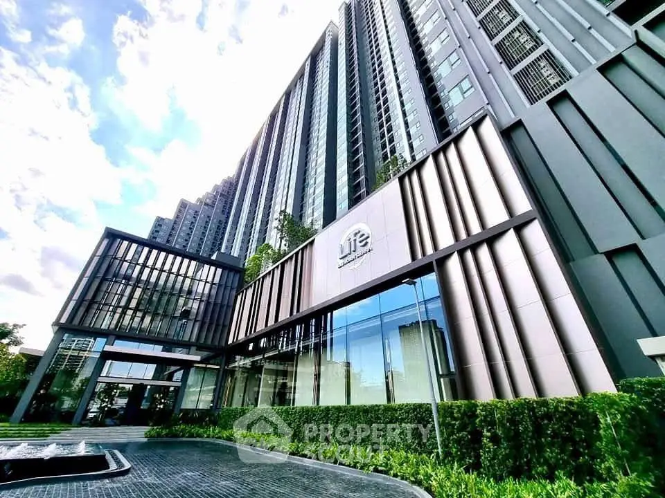 Modern high-rise building with sleek architecture and lush landscaping