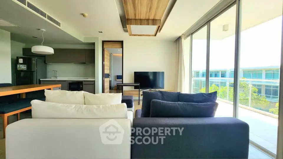 Modern living room with large windows and balcony view in a stylish apartment.
