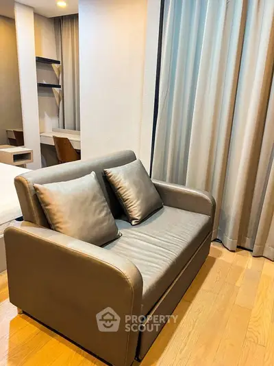 Cozy modern living room with stylish sofa and elegant curtains, perfect for relaxation.
