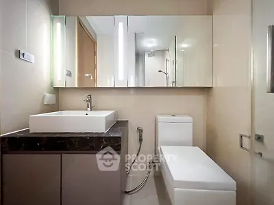 Modern bathroom with sleek fixtures and large mirror in a contemporary apartment.