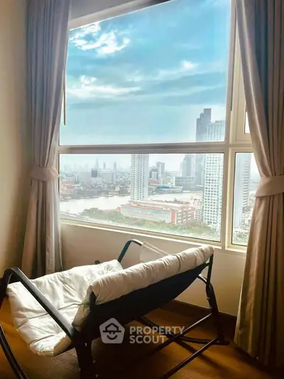 Stunning city view from a cozy room with large windows and elegant curtains, perfect for relaxation.