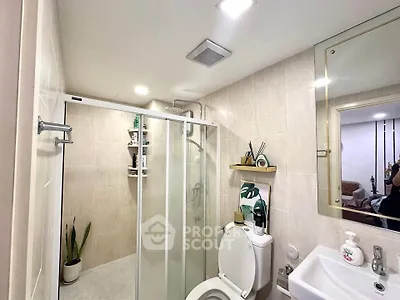 Modern bathroom with glass shower, sleek fixtures, and elegant decor.