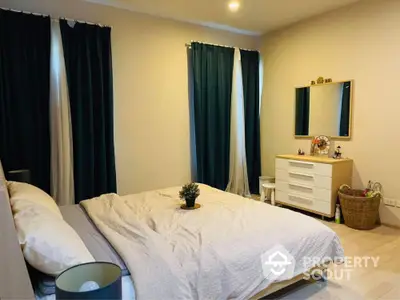 Cozy bedroom with elegant decor and ample natural light, perfect for relaxation.