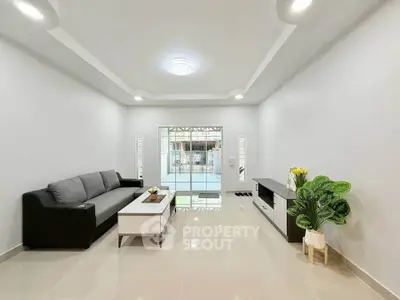 Spacious modern living room with sleek furniture and large window for natural light.