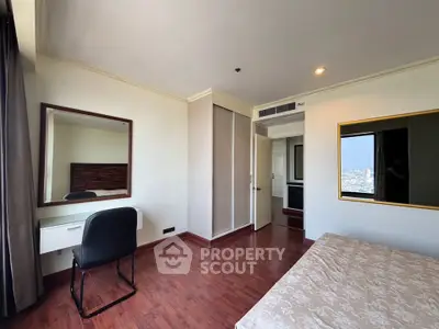 Spacious bedroom with city view, featuring elegant wooden flooring and modern furnishings.