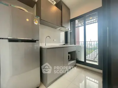 Modern kitchen with sleek cabinets and balcony view in a stylish apartment.