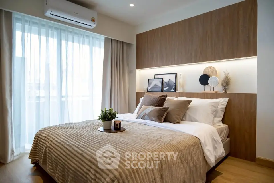 Modern bedroom with stylish decor and natural light, featuring a cozy bed and elegant wooden accents.