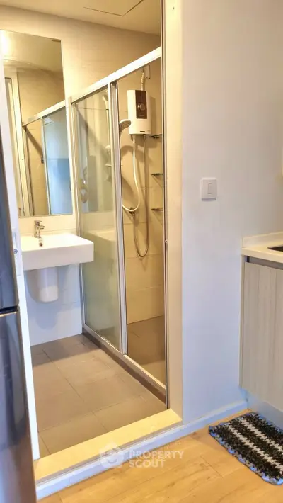 Modern bathroom with glass shower and sleek fixtures in contemporary apartment.