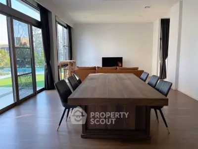 Spacious living room with elegant dining area and pool view