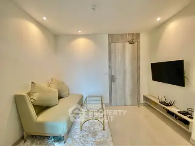 Modern living room with sleek sofa, wall-mounted TV, and elegant decor in a stylish apartment.