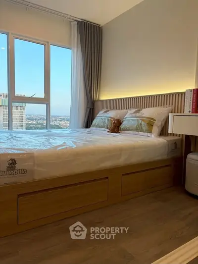 Cozy bedroom with large window offering stunning city view, featuring a comfortable bed and elegant decor.