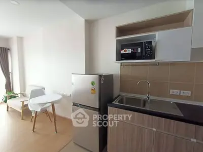 Modern kitchen with sleek appliances and dining area in a stylish apartment.