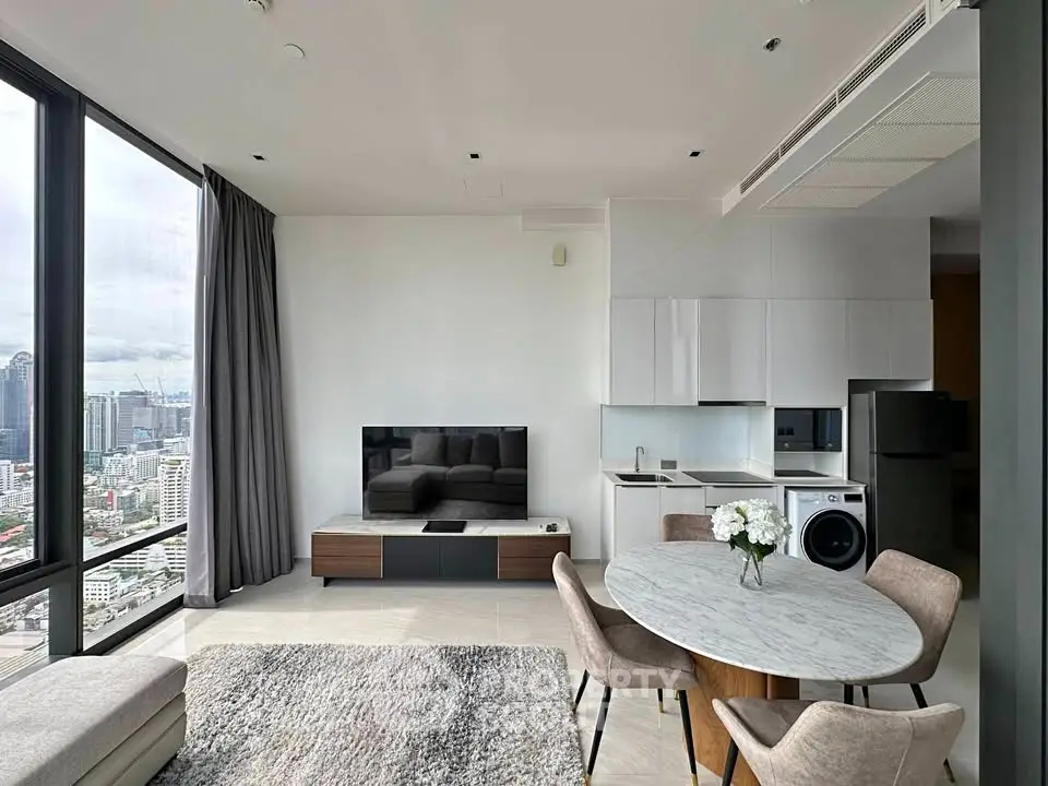 Modern living room with city view, open kitchen, and stylish furniture