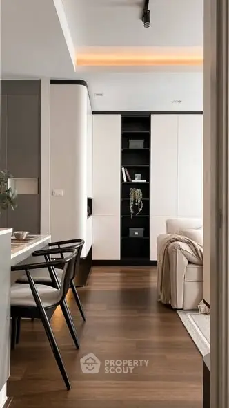 Modern living room with sleek furniture and elegant decor, featuring a cozy sofa and stylish shelving.