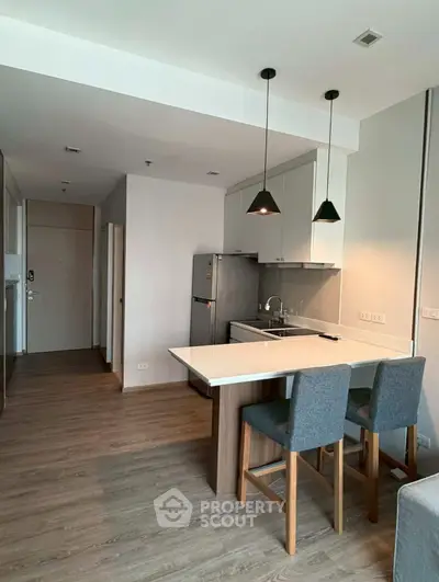 Modern kitchen with open layout and stylish lighting in a cozy apartment.