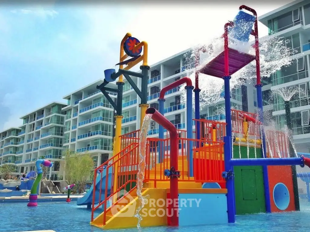 Vibrant water play area in modern residential complex with spacious balconies.