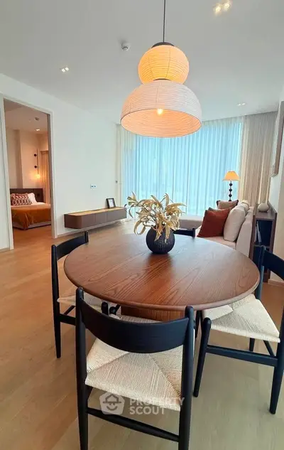 Modern open-plan living room with stylish dining area and cozy bedroom view.