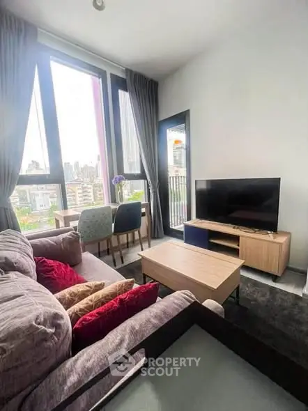 Modern living room with city view, stylish furniture, and large windows for natural light.
