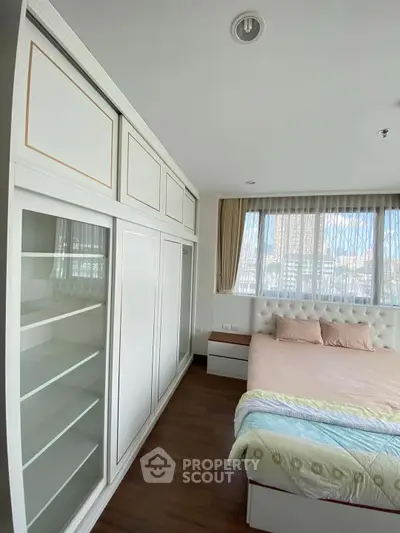 Bright and cozy bedroom with large windows and built-in storage