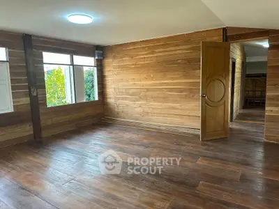 Spacious wooden interior with natural light and open doorway, perfect for customization.