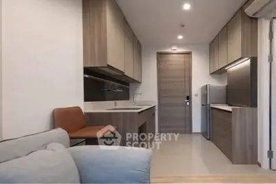 Modern kitchen with sleek cabinetry and stainless steel appliances in a cozy apartment.