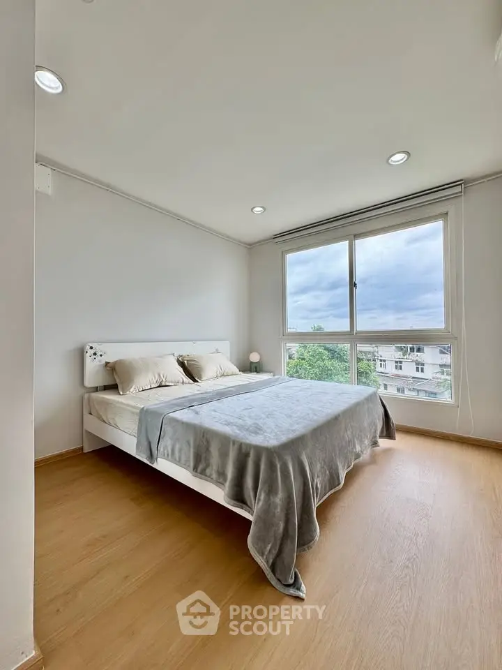 Bright and airy bedroom with large window and cozy decor