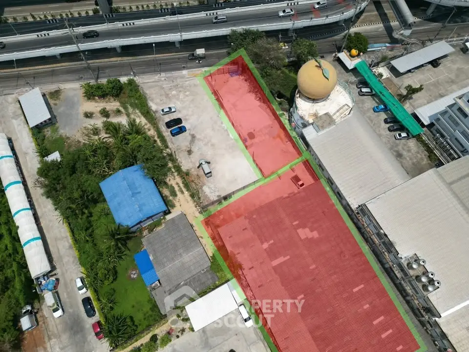 Aerial view of commercial property with parking and road access, ideal for development.