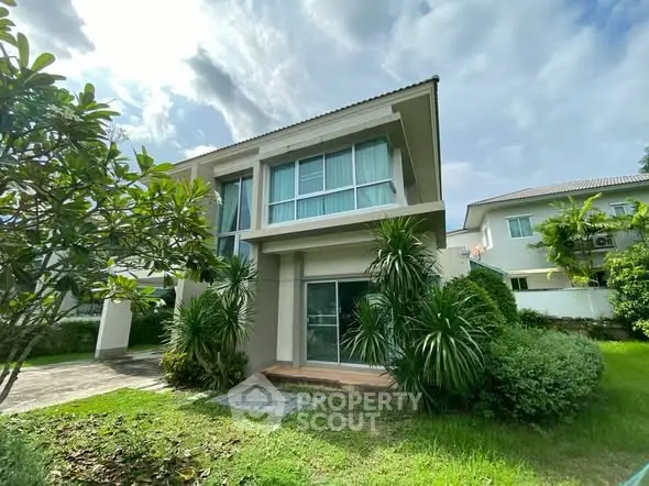 Modern two-story house with lush garden and large windows