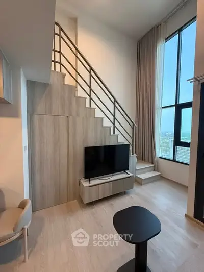 Modern duplex living room with high ceilings and large windows offering a stunning city view.