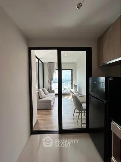 Modern apartment with open layout, sleek kitchen, and stunning city view from the living room balcony.