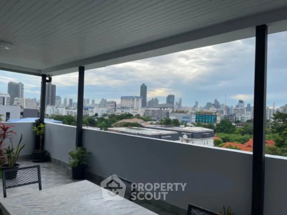 Stunning rooftop view of city skyline with modern outdoor seating area.