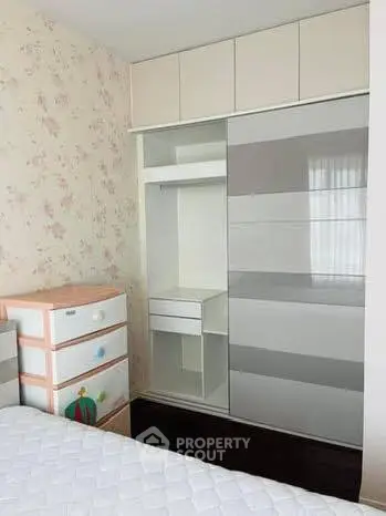 Charming bedroom with built-in wardrobe and floral wallpaper, perfect for cozy living.