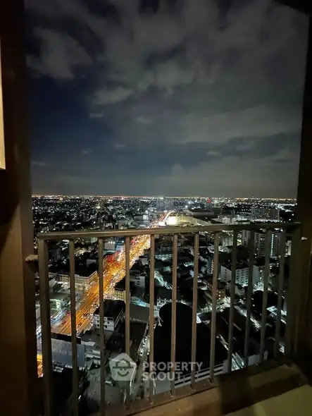 Stunning cityscape view from high-rise balcony at night, showcasing vibrant urban lights and skyline.