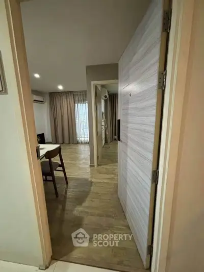 Spacious apartment entrance with wooden flooring and modern decor