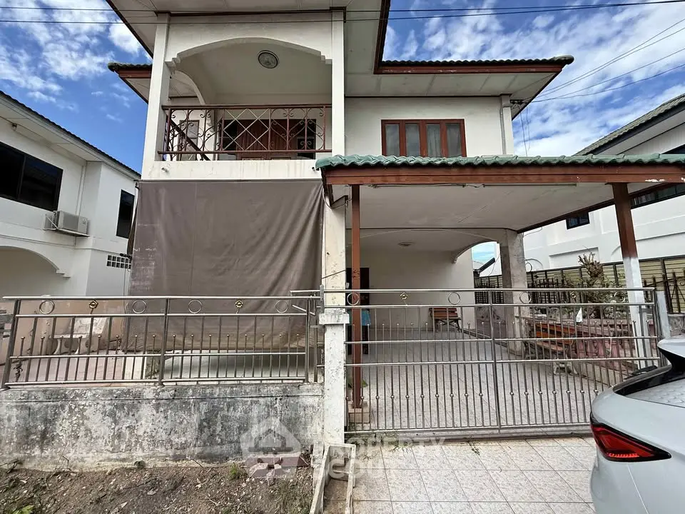 Charming two-story house with gated driveway and balcony in a serene neighborhood.