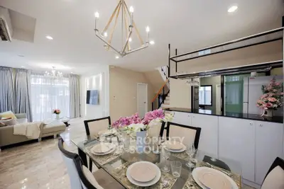 Luxurious open-plan living and dining area with elegant chandelier and modern decor