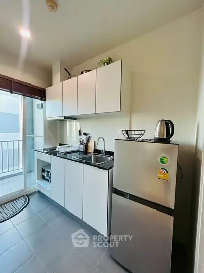 Modern kitchen with sleek cabinets and stainless steel appliances in a bright apartment.