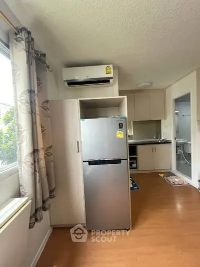 Modern kitchen with fridge and air conditioning in cozy apartment