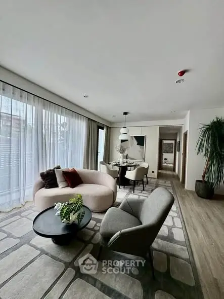 Stylish modern living room with elegant furniture and large windows in a contemporary apartment.