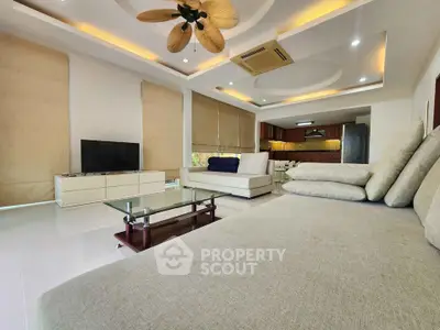 Spacious modern living room with elegant ceiling design and open kitchen layout.