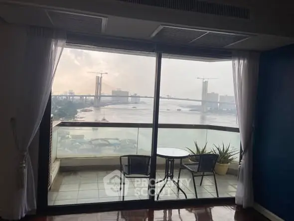 Stunning river view from a cozy balcony with seating, perfect for relaxation.