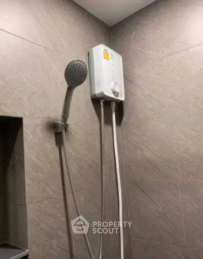 Modern bathroom with sleek shower head and water heater on tiled wall.