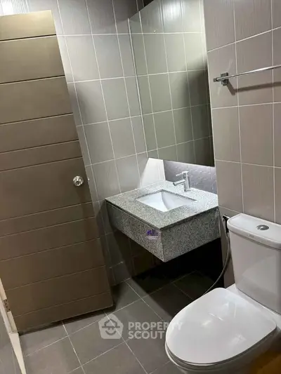 Modern bathroom with sleek sink and toilet in contemporary design.