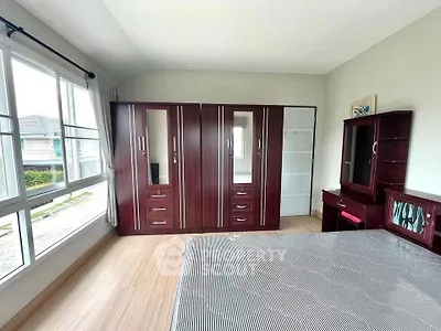 Spacious bedroom with large windows and elegant wooden furniture