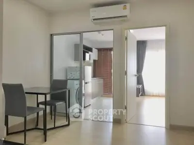Modern apartment interior with open kitchen and dining area, featuring sleek furniture and appliances.