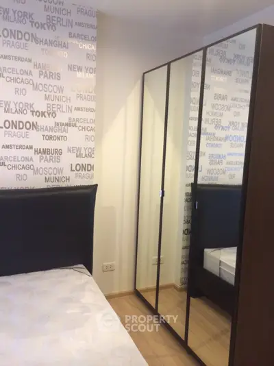 Modern bedroom with mirrored wardrobe and city-themed wallpaper